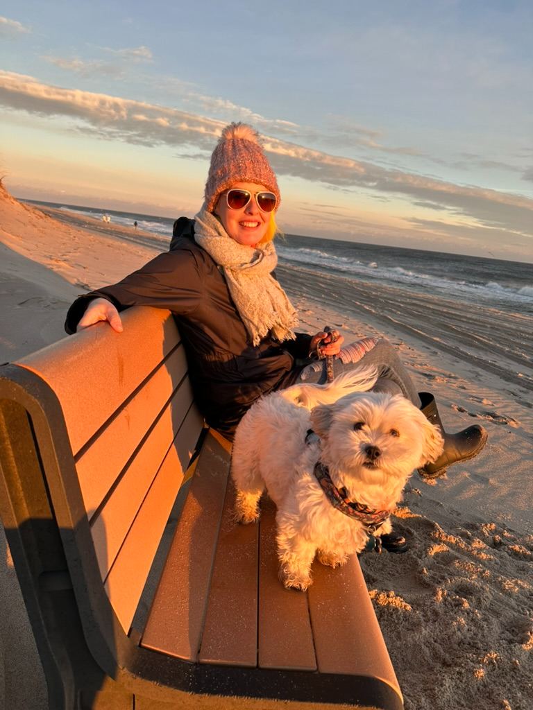 Britta and a dog at the beach at sunset