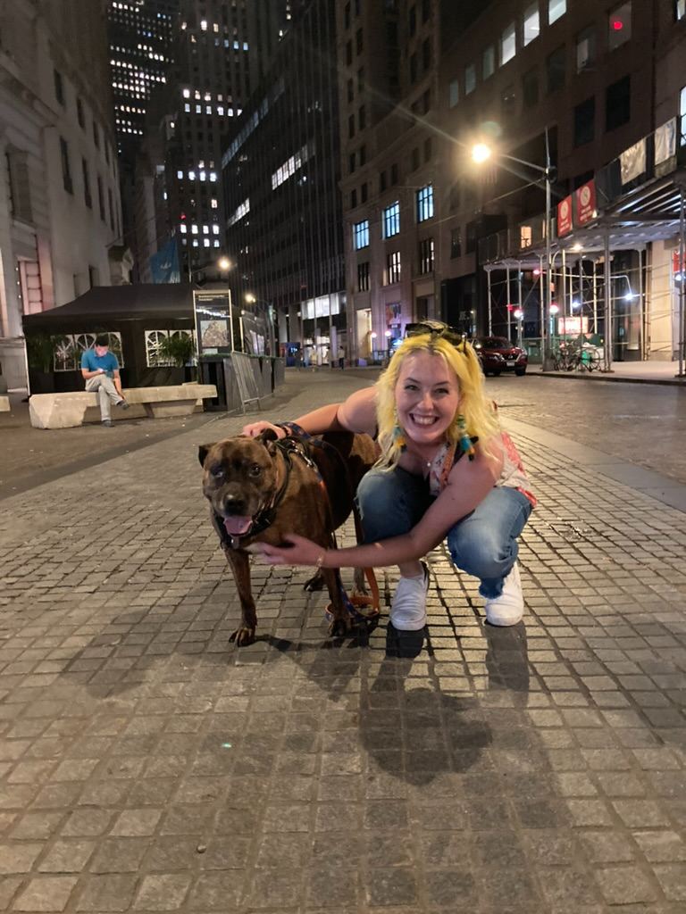 Britta with a dog on a Manhattan street at night