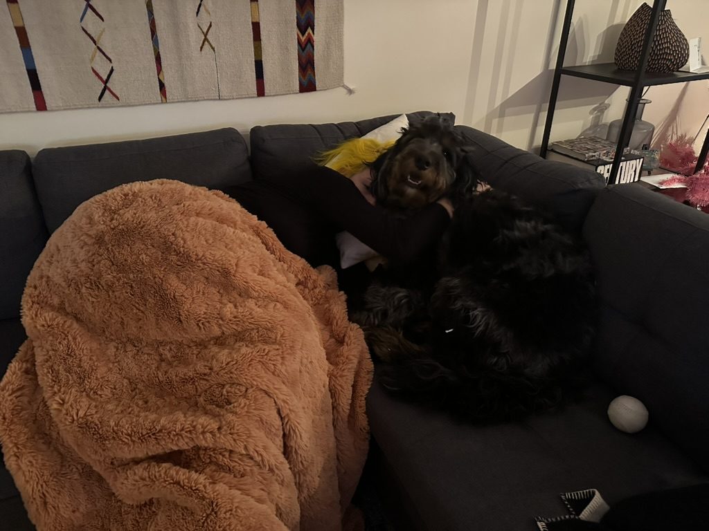 Britta cuddling a dog on a couch