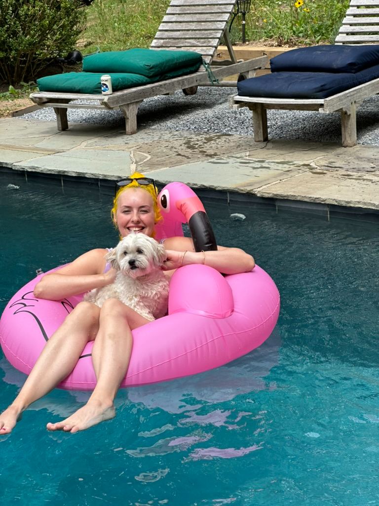 A dog by the pool with a flamingo float
